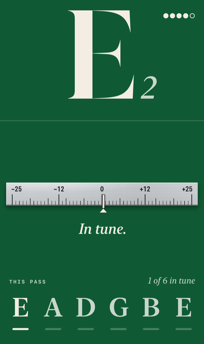The whole tuner screen green. A large E sits centred over a white needle, with “In tune.” beneath it.